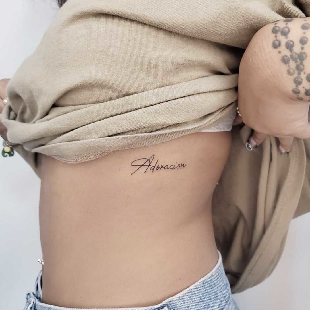 Tattoo with the word 'Adoracion' on a person's side