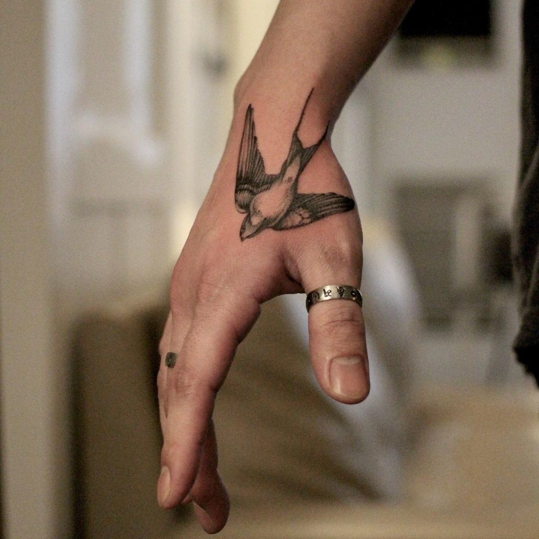 Hand tattoo of a bird in flight