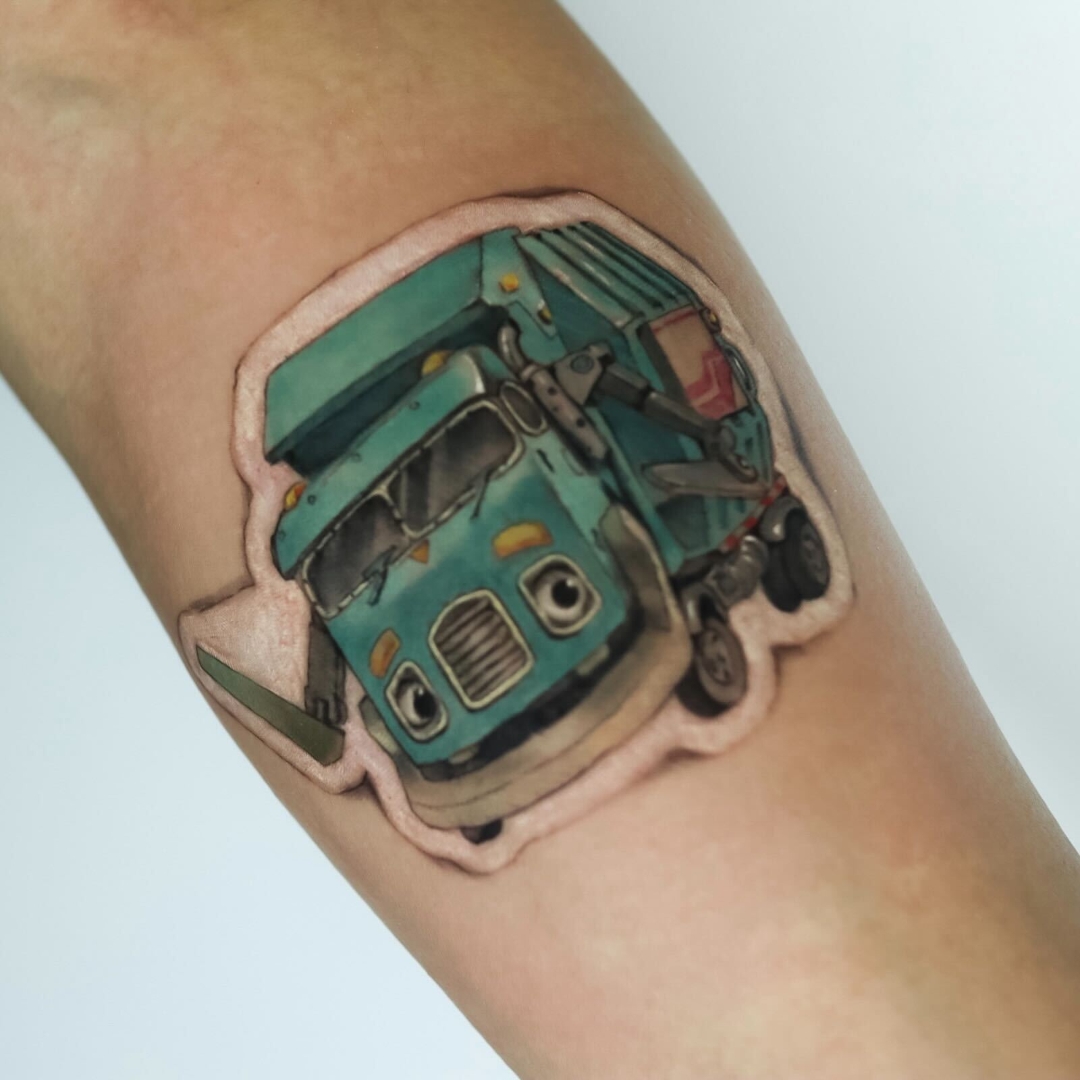 Colorful tattoo of a cartoon garbage truck on an arm