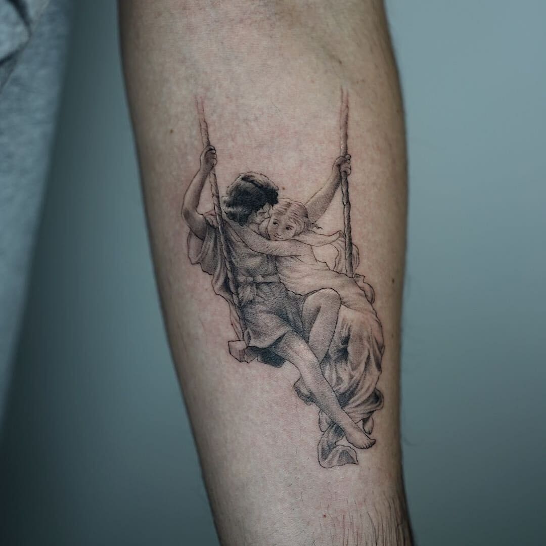 Detailed tattoo of a child and adult on a swing