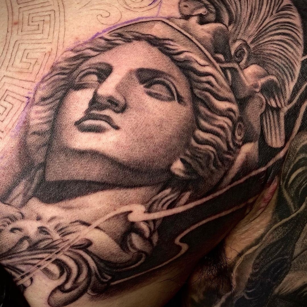 Intricate tattoo of a classical statue design on skin.