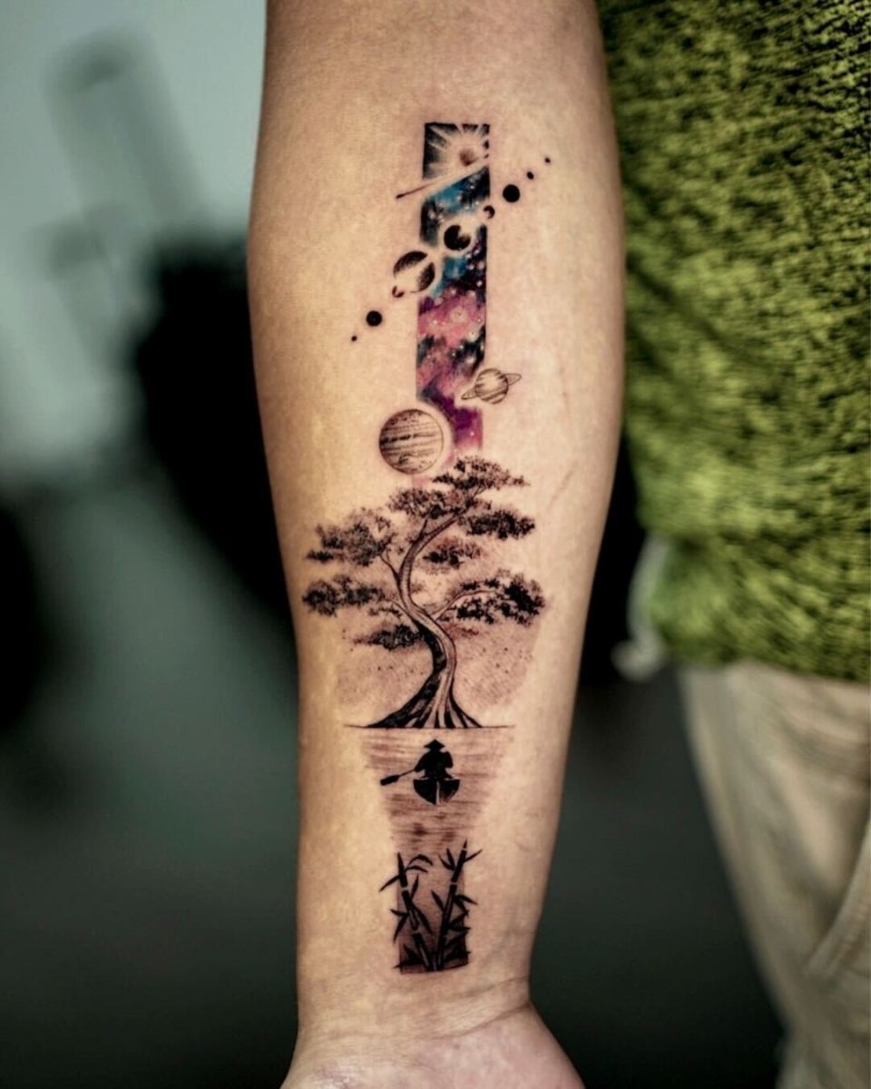 Tattoo of a tree and planets on an arm