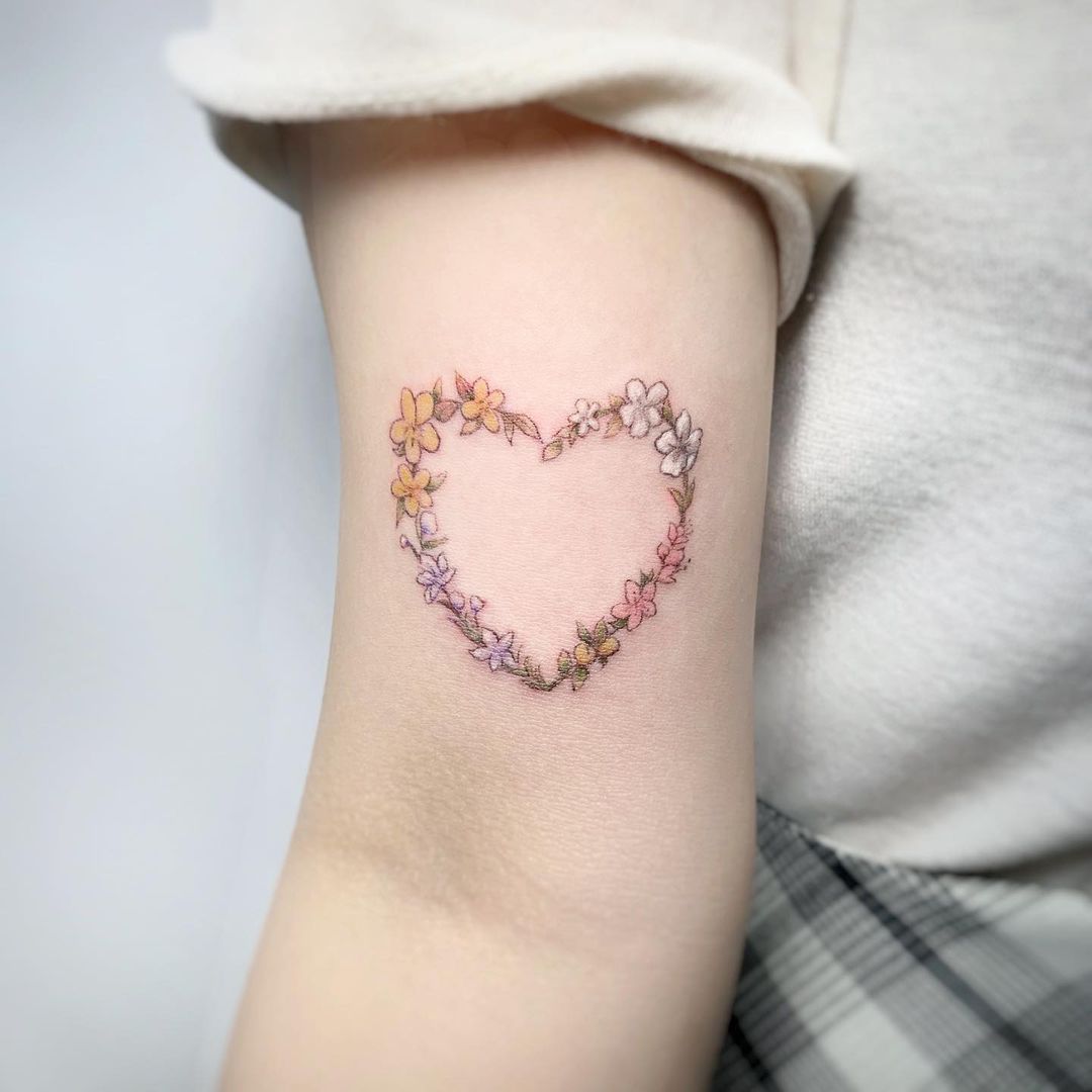 Delicate floral heart tattoo on arm
