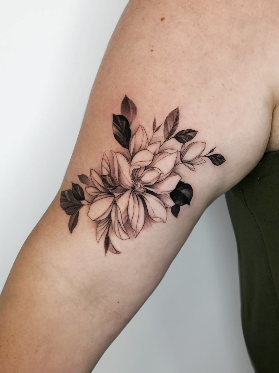 Black and grey floral tattoo on a woman's arm