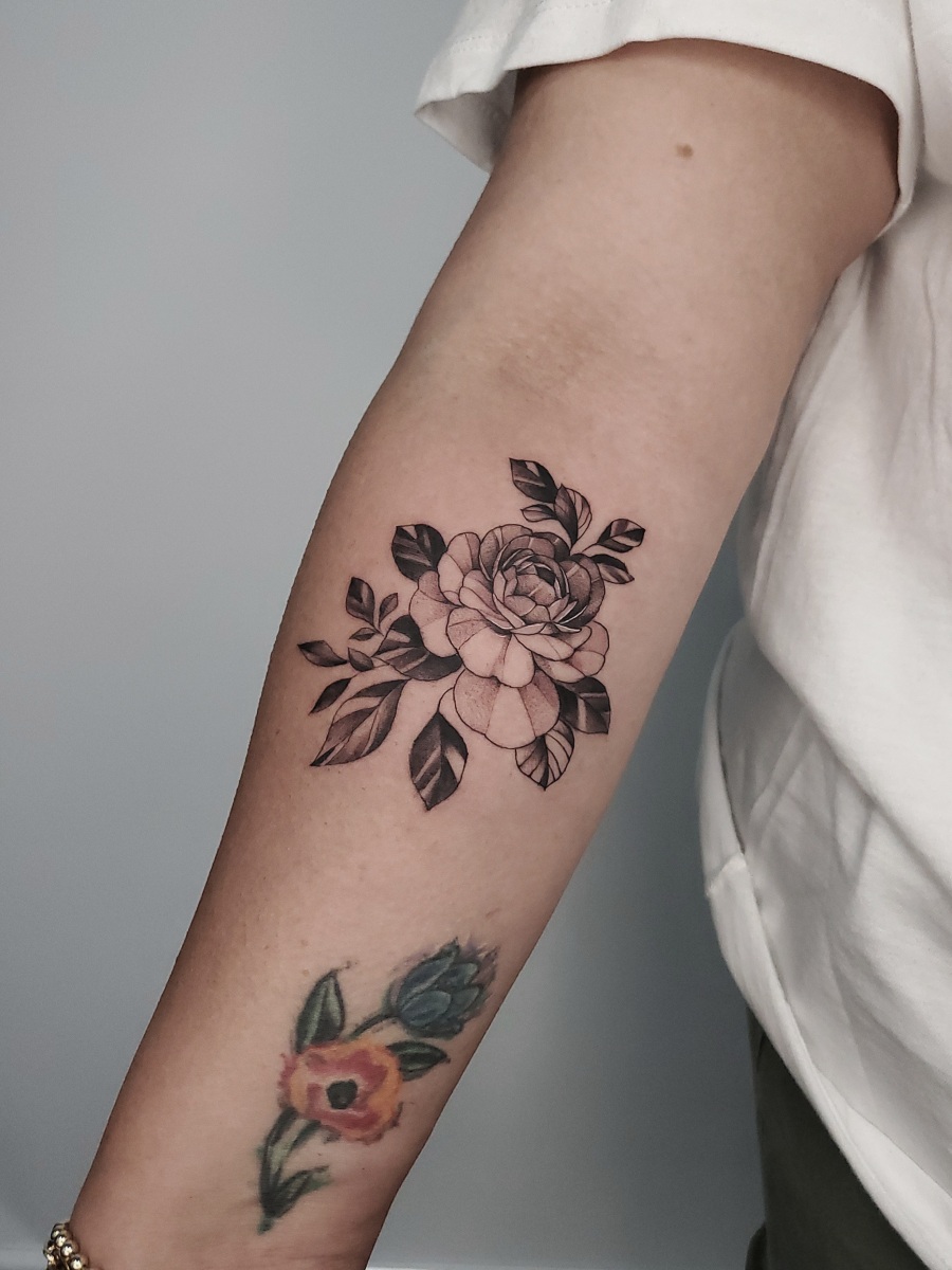 Black and gray floral tattoo on an arm
