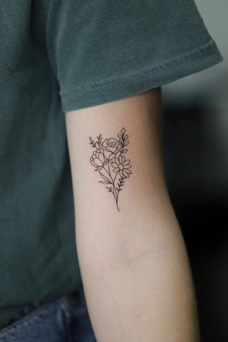 Black ink floral tattoo on arm