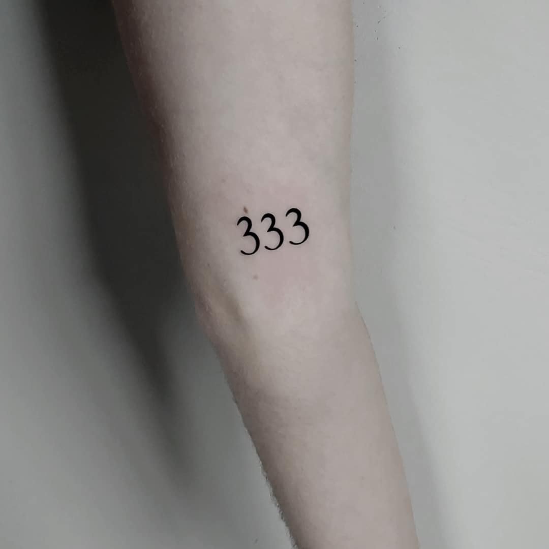 Close-up of a tattoo on a forearm with the numbers 333