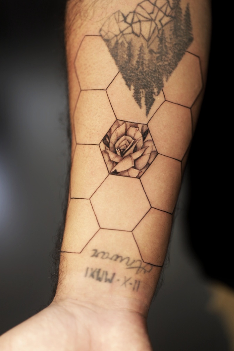 Black and gray hexagonal-themed tattoo on forearm