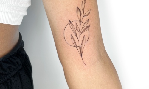 Delicate botanical tattoo design on arm