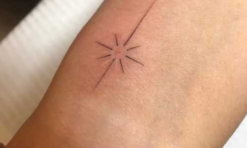 Minimalist sun tattoo on wrist