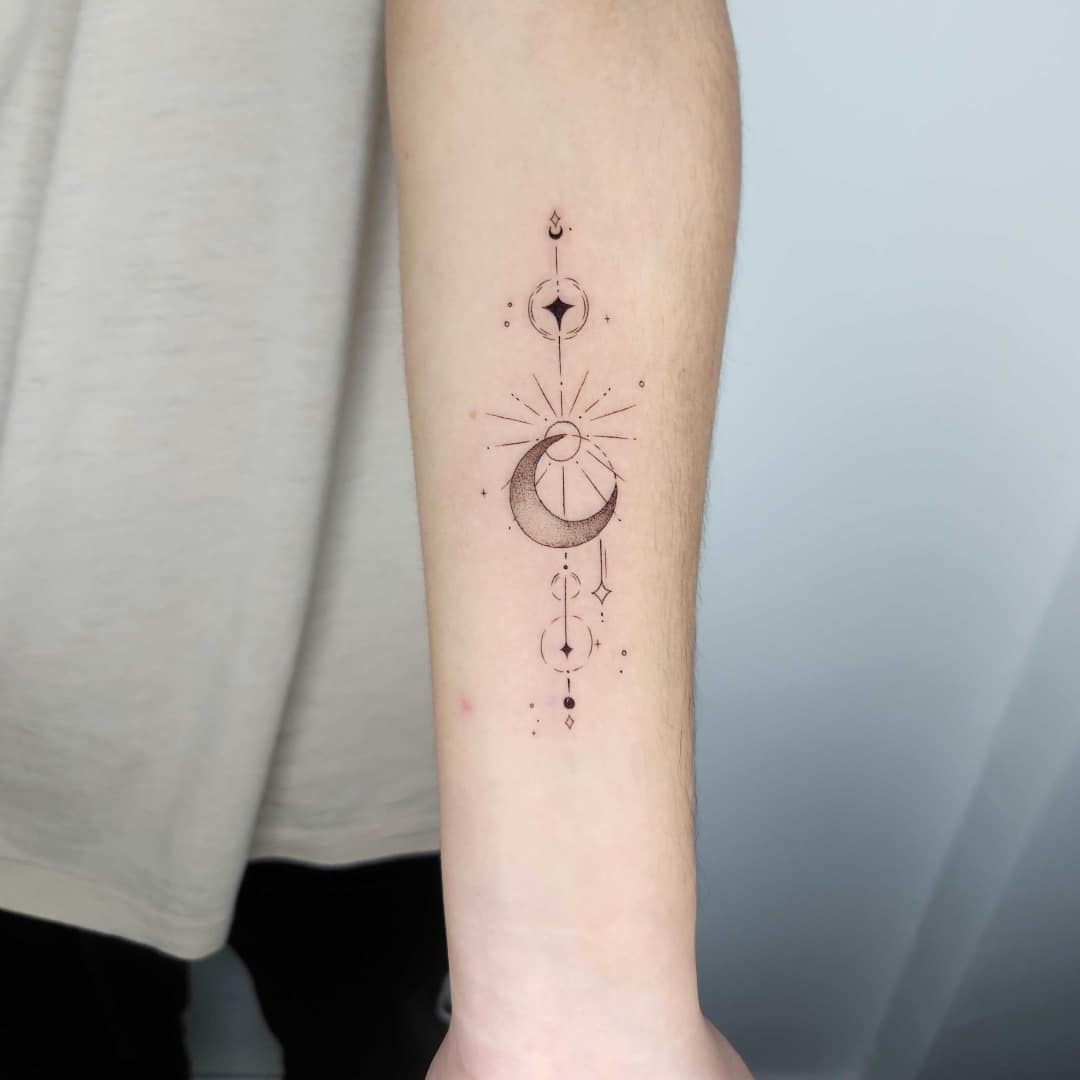 Tattoo of moon and star design on forearm
