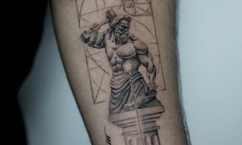 Detailed tattoo of a muscular figure holding a hammer, symbolizing strength.