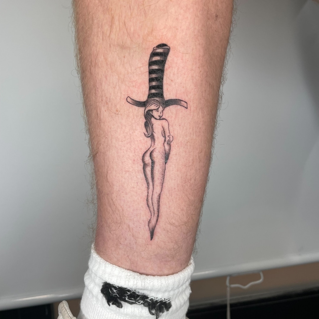 Tattoo of a woman with a striped hat on the leg