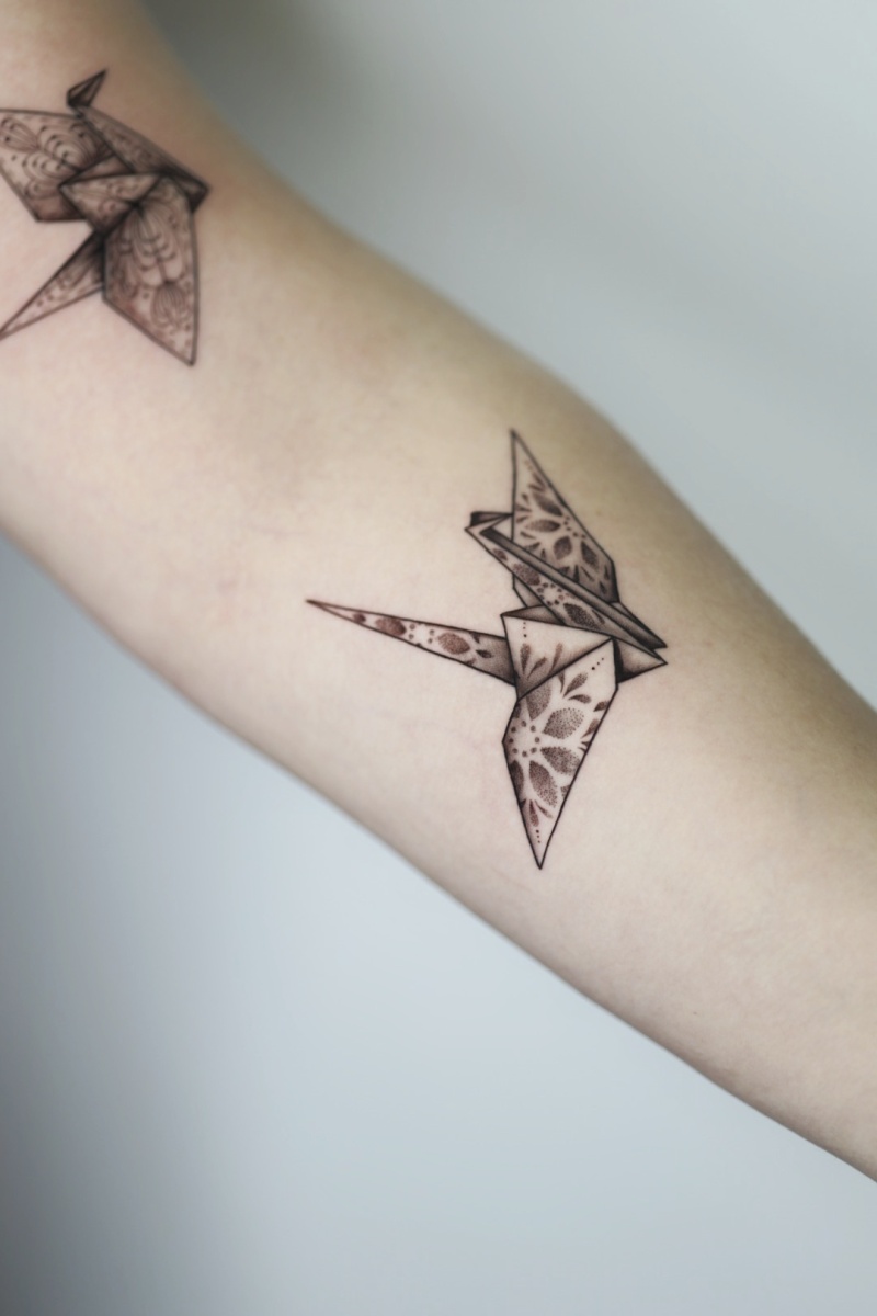 Tattoo of intricate origami crane on arm