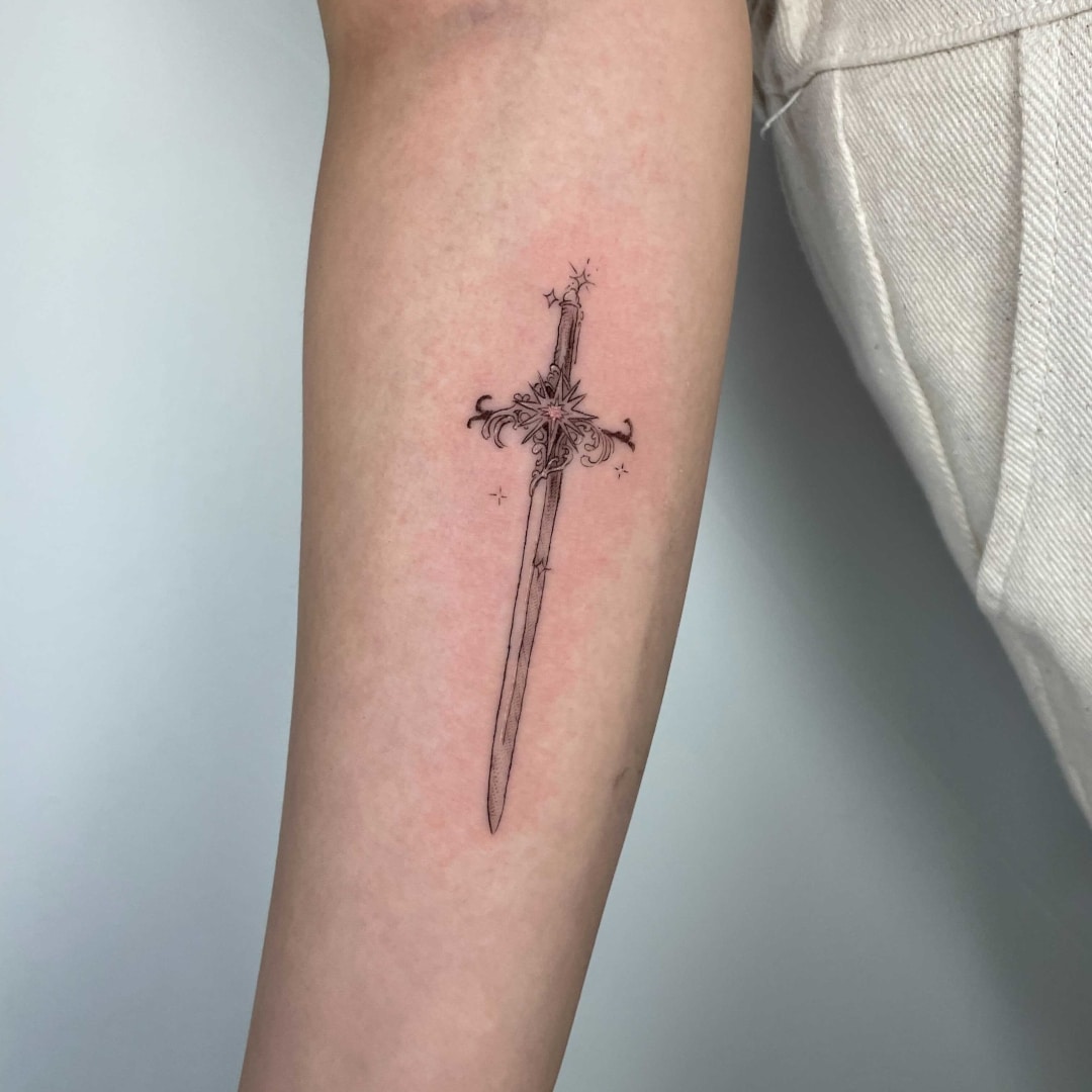 Tattoo of a decorative sword on a forearm