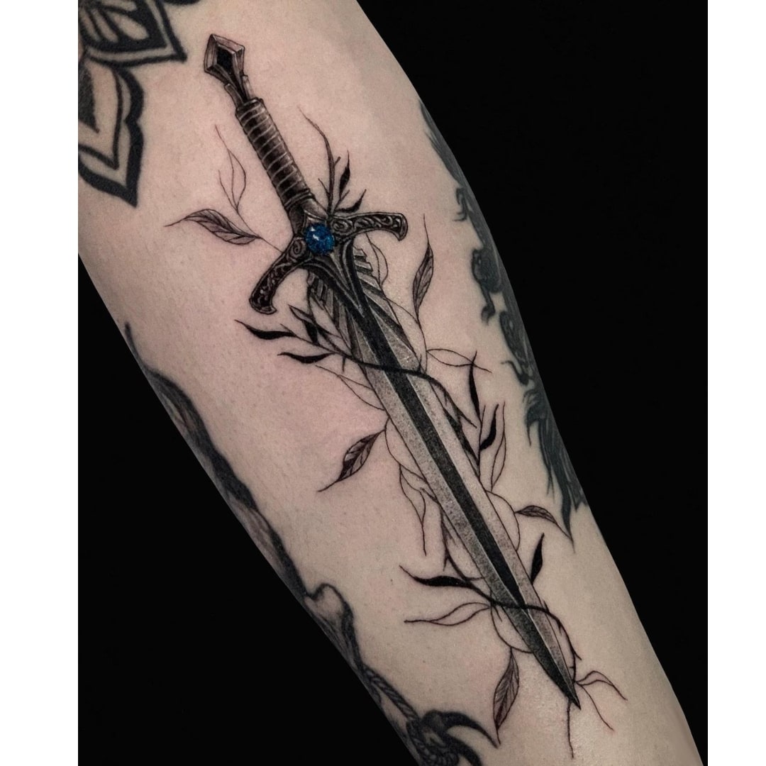 Tattoo of a sword entwined with vines on a forearm