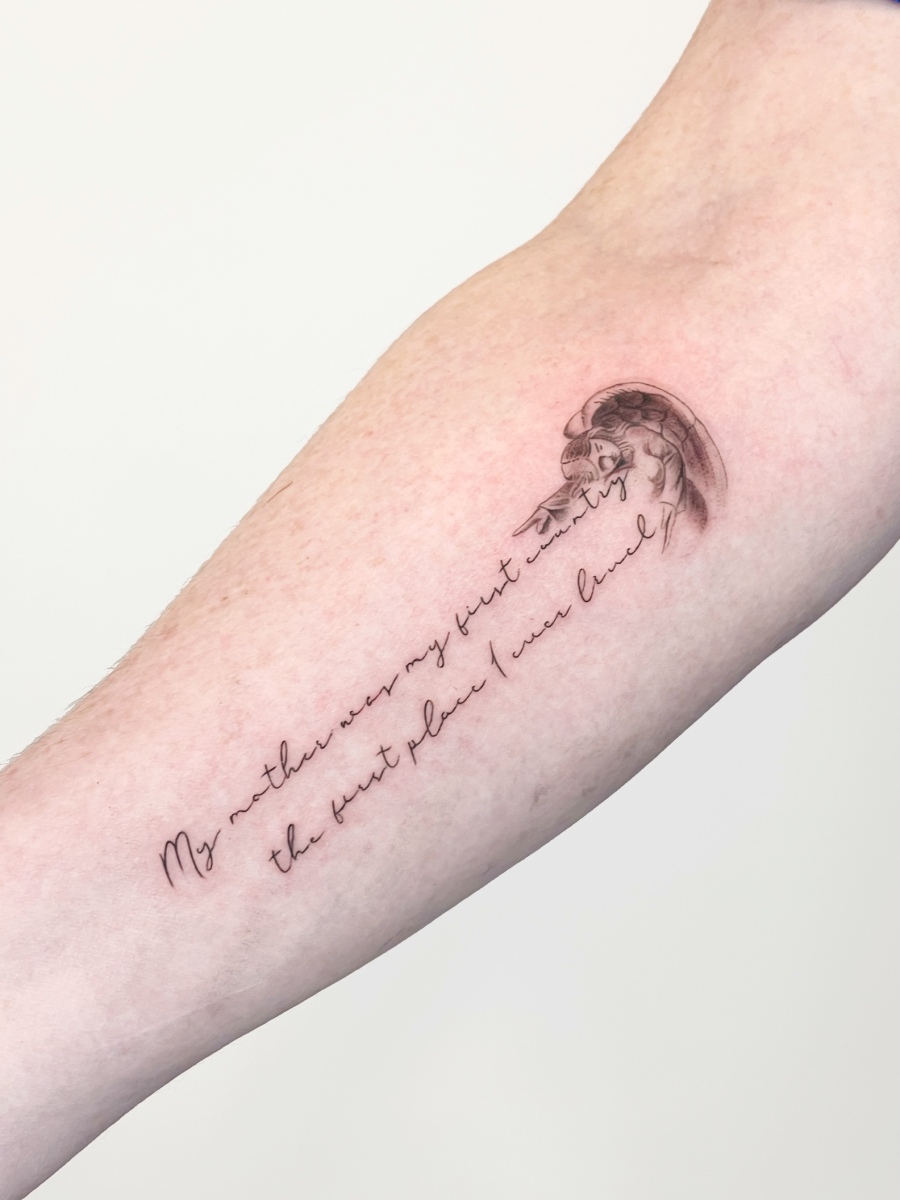 A tattoo featuring an illustration and handwritten quote on a forearm.