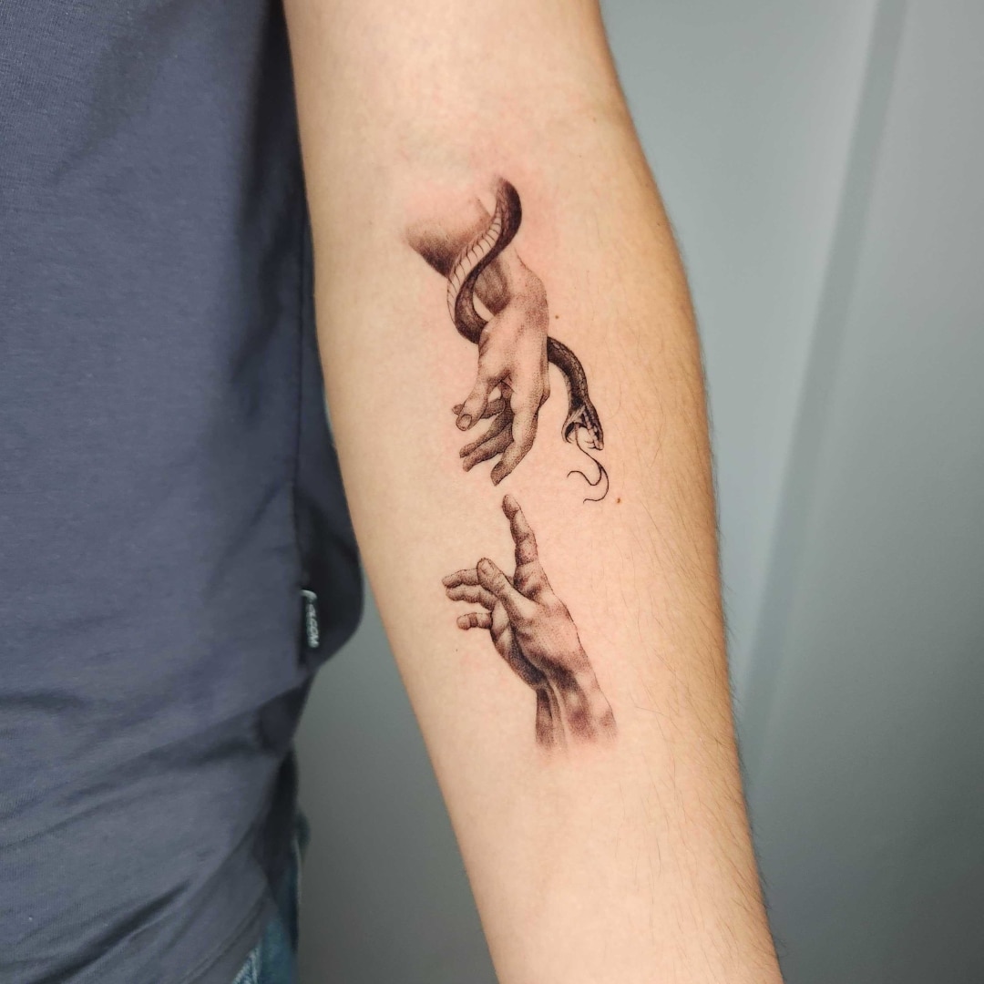 Tattoo of hands and snake on arm