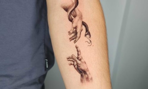 Tattoo of hands reaching towards each other with a snake