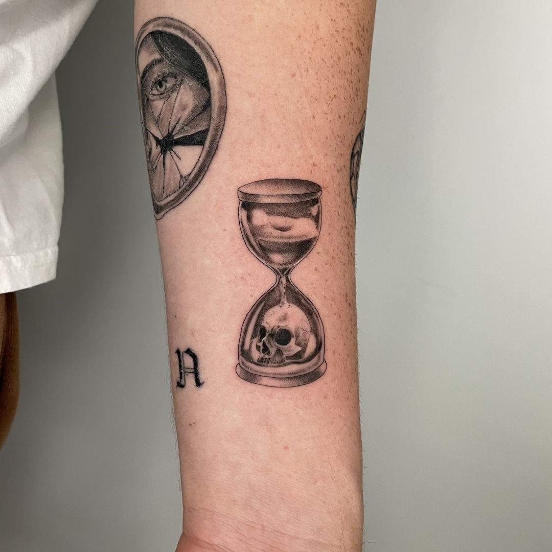 Tattoo of hourglass with skull on arm