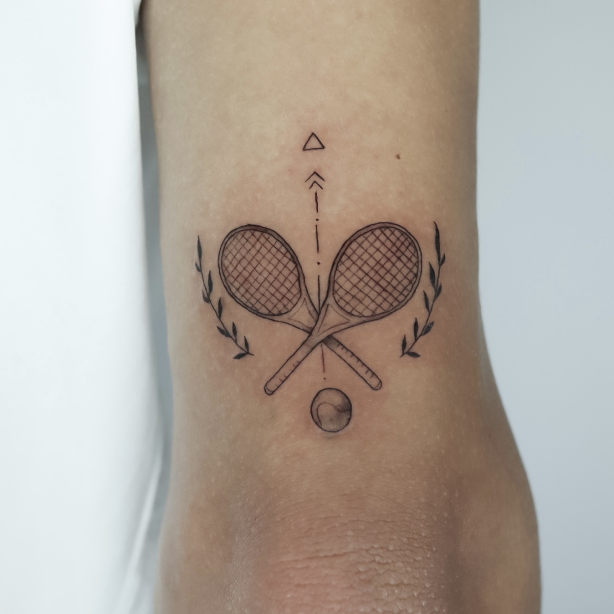 Tattoo design featuring tennis rackets and a ball