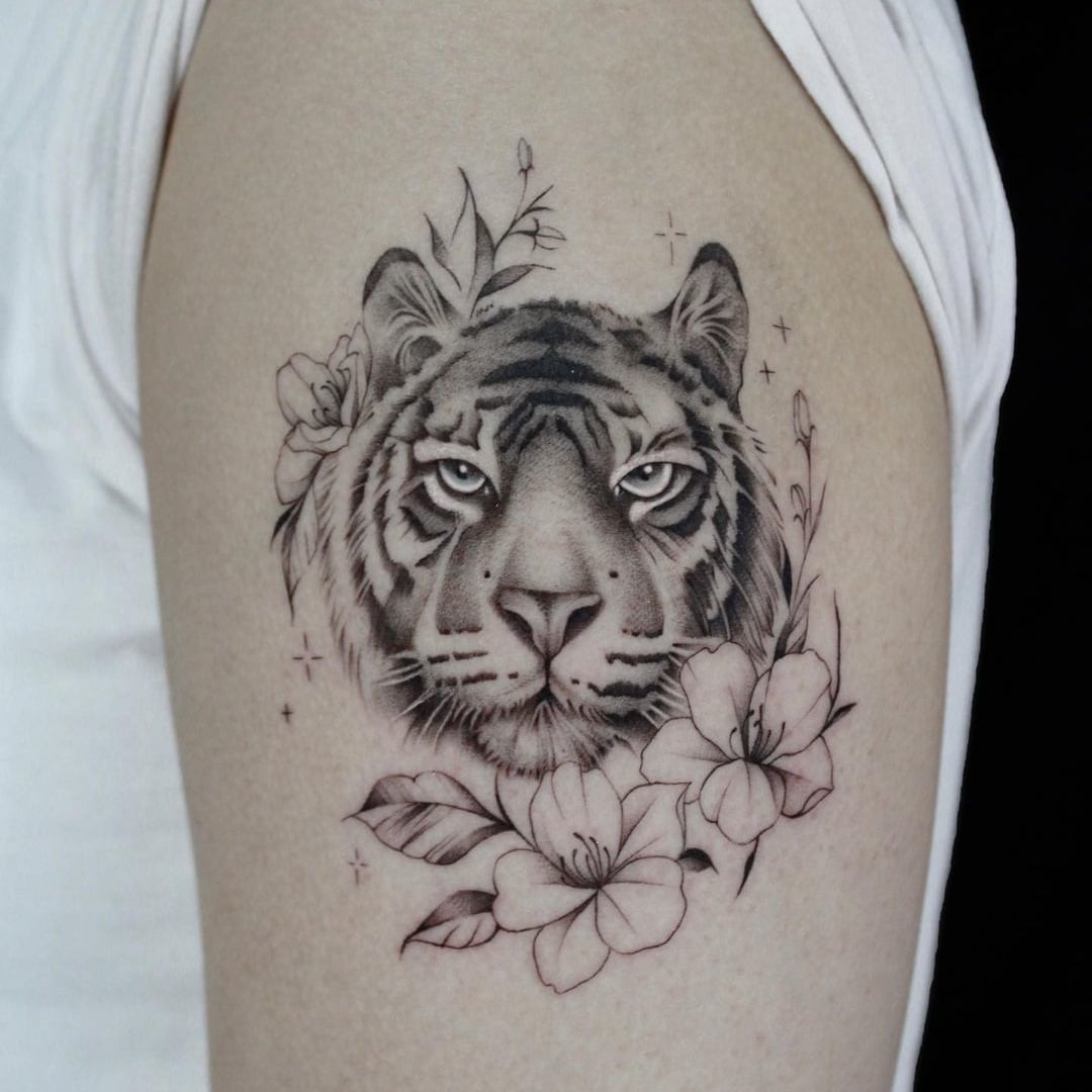 Realistic black and grey tiger tattoo with flowers