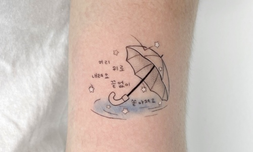 Tattoo design featuring an umbrella and stars on a forearm