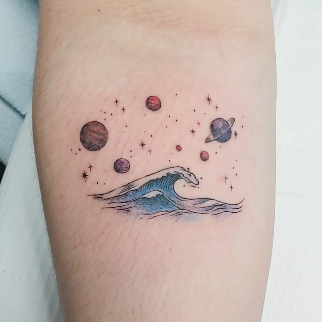 A colorful tattoo depicting ocean waves and planets