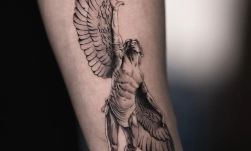 Detailed tattoo design of a winged figure on an arm