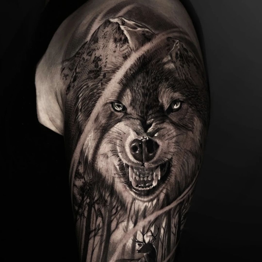 A detailed black and gray tattoo of a wolf on an arm
